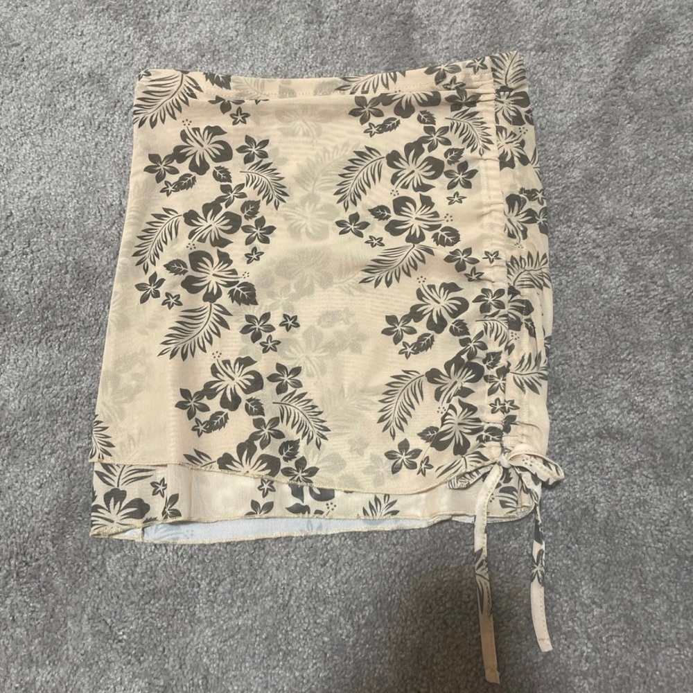 Mini skirt is beige with black flowers. Size M/6.